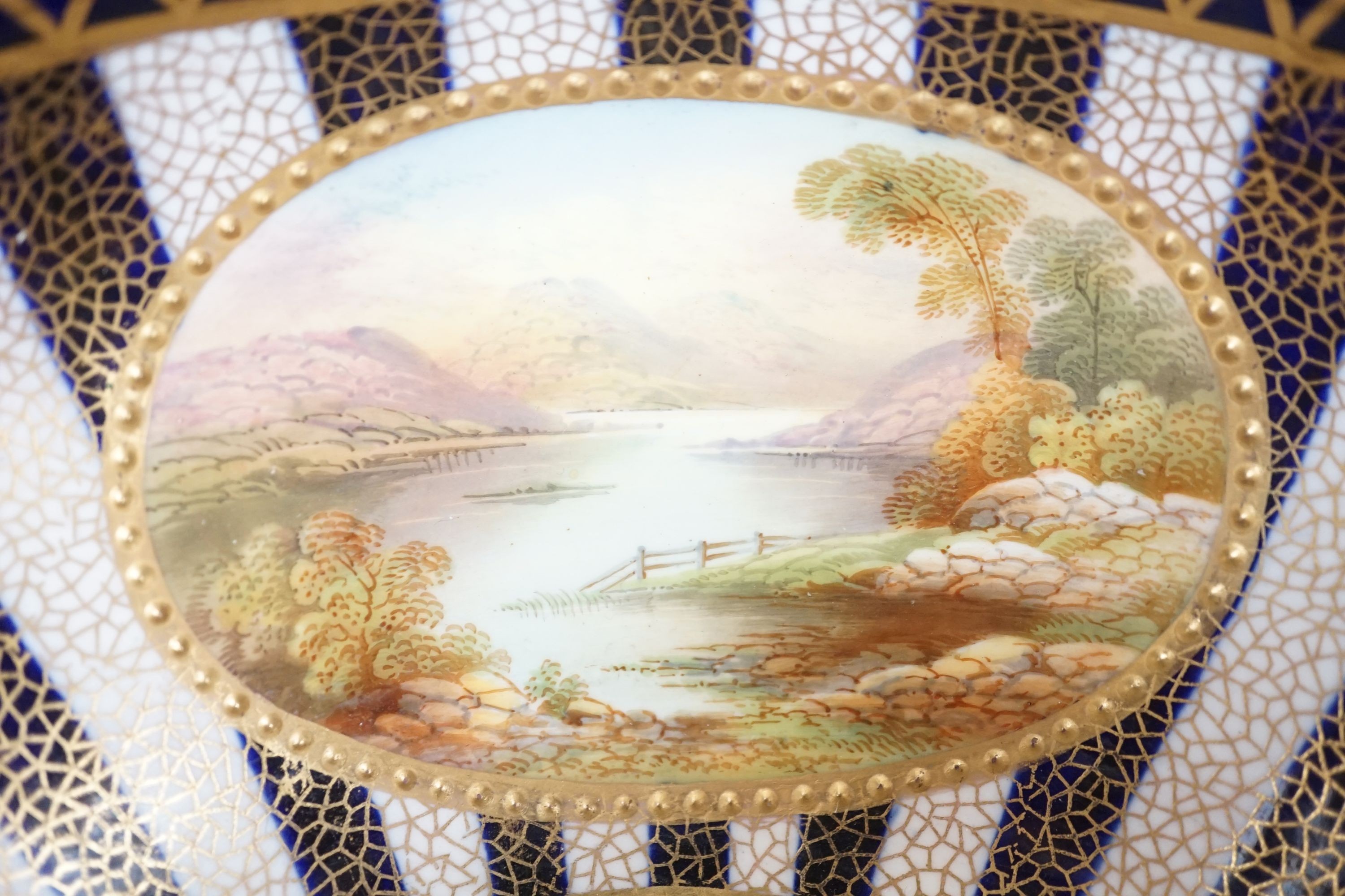 An Aynsley fine bowl with three interior landscape panels and three exterior panels painted with birds between alternating blue and white gilt stripes four panels signed R.J.K. for Richard J. Keeling, c.1910, height 10.5